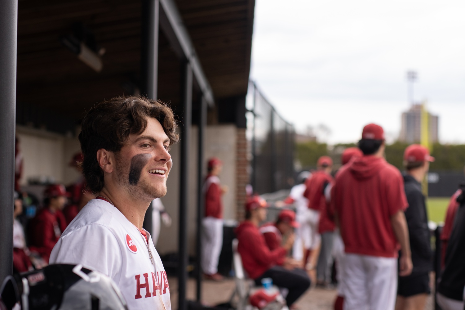 Jack Rickheim smiles in the Harvard dugout during a game against Dartmouth. 