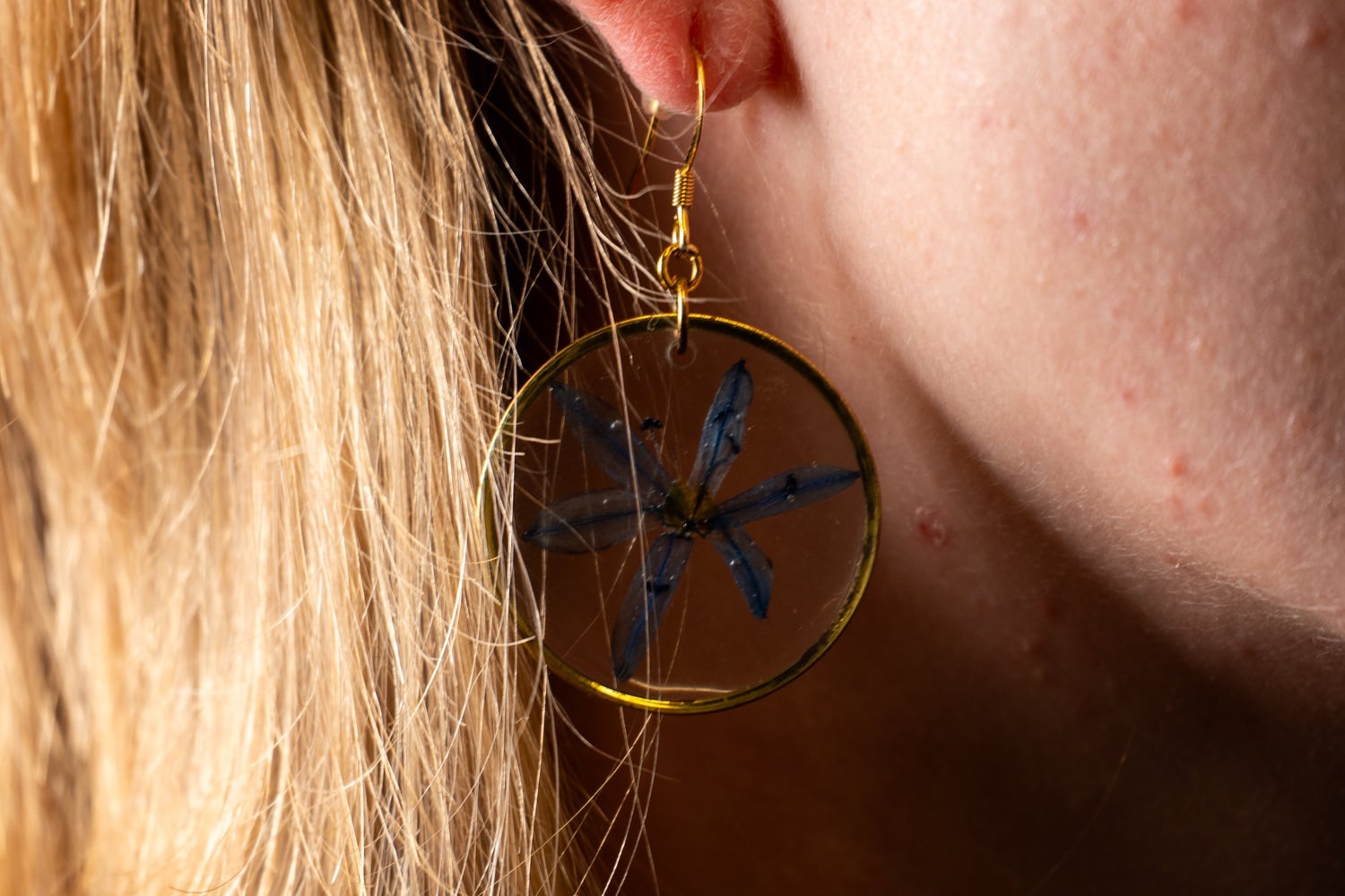 Megan L. Blonigen frequently wears the earrings she bought at her first Pride. They are blue flowers set in resin.