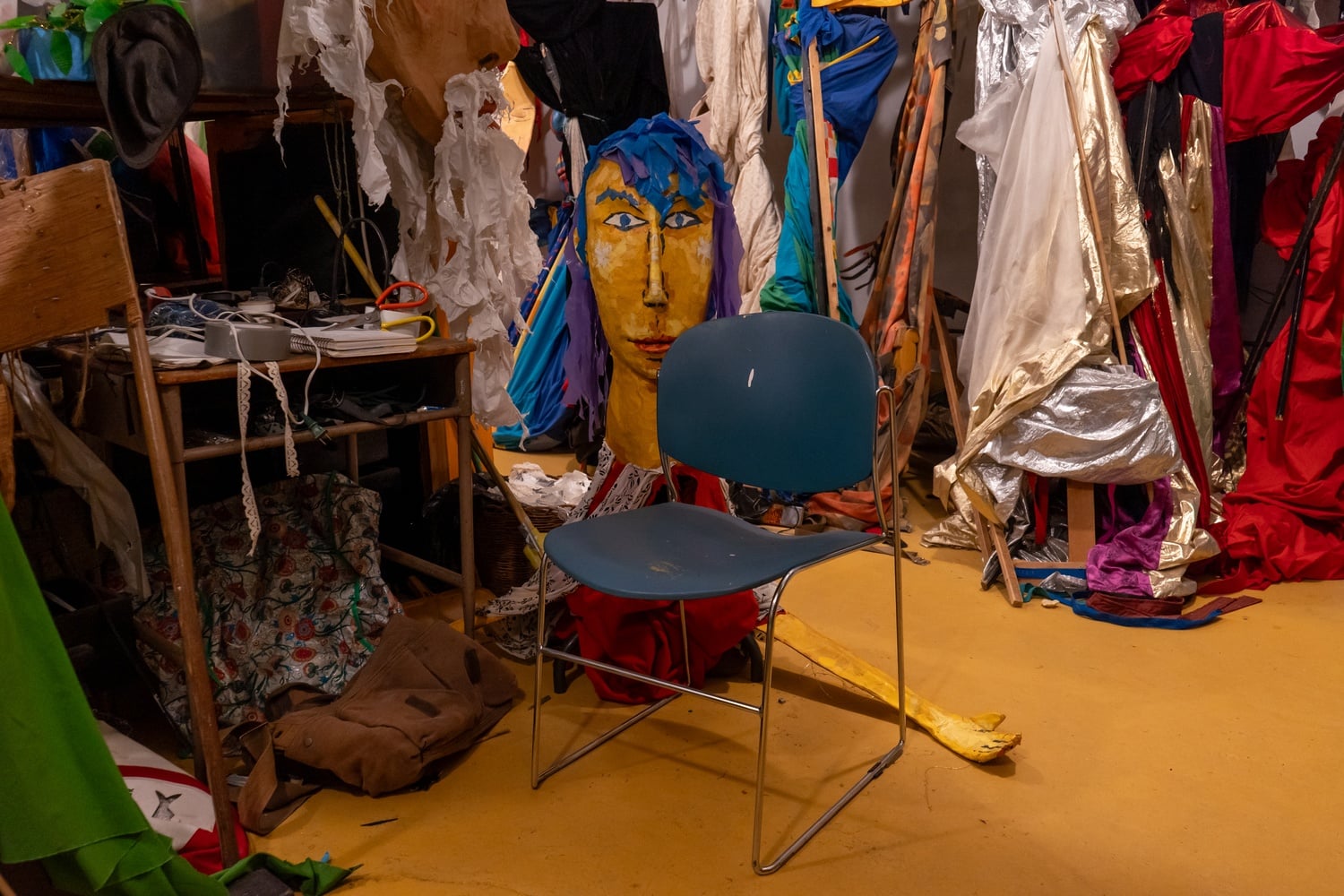 A composition notebook that serves as a borrowing ledger rests on a table amidst a cluster of puppets.