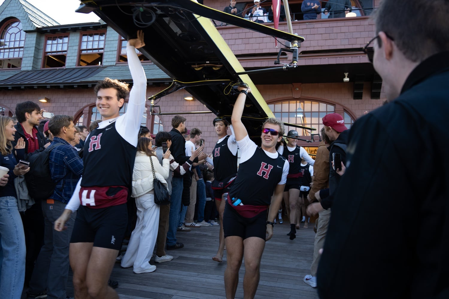Senior Sam Gallaudet and captain Marco Gandola carry the 1V boat down the docks at Newell Boathouse.
